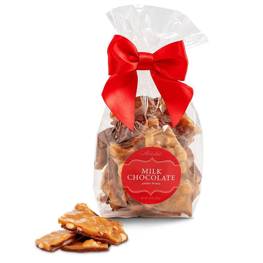 Bag of Abdallah Candies Milk Chocolate Peanut Brittle tied with a red bow, with pieces of peanut brittle displayed in front.