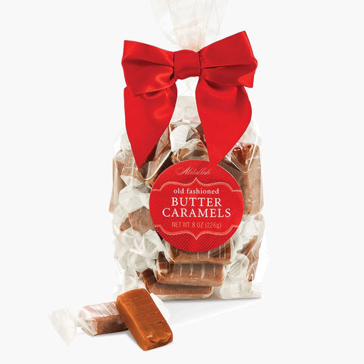 Bag of Abdallah Candies Twist Wrap Butter Caramels with red bow and individually wrapped caramel pieces displayed in front.