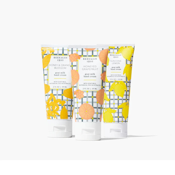 Three body lotion tubes adorned with colorful lemon and orange graphics.