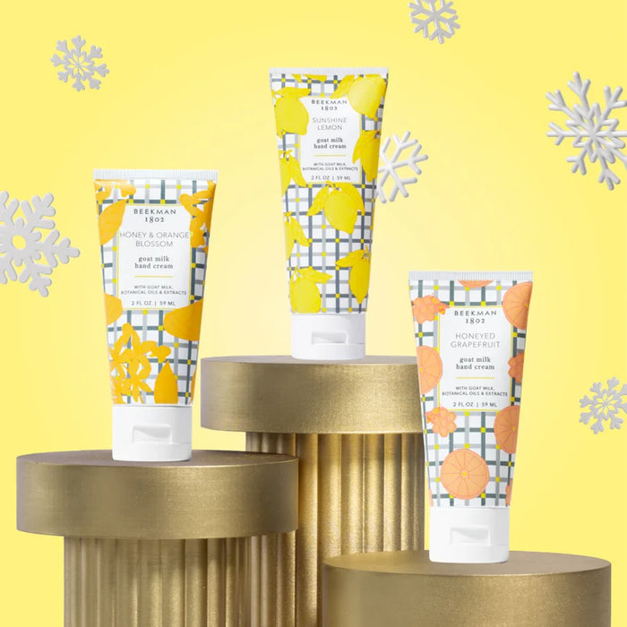 Three body lotion tubes adorned with colorful lemon and orange graphics.