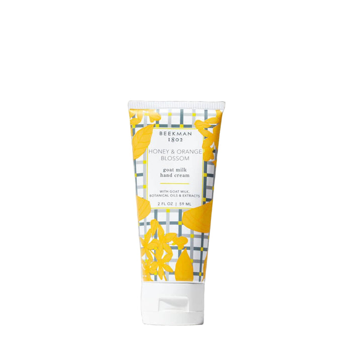 Beekman 1802 hand cream tube with yellow floral design on a white background. Honey Orange blossom scent.