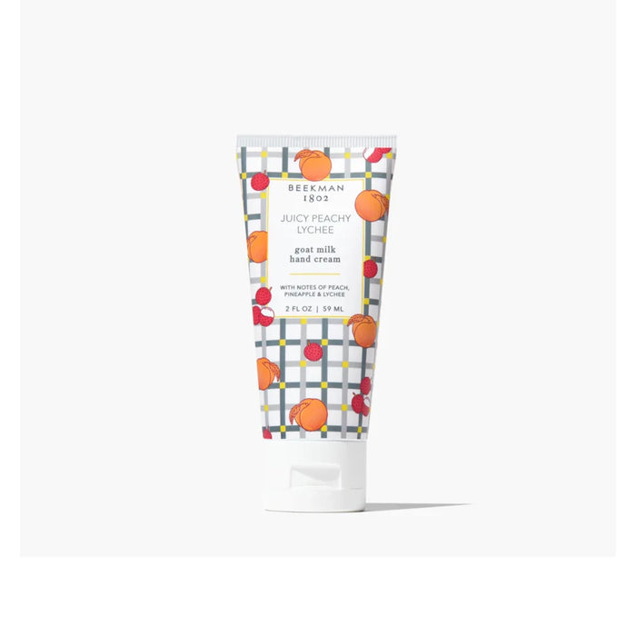 A tube of hand cream surrounded by fresh oranges and berries on a light background.