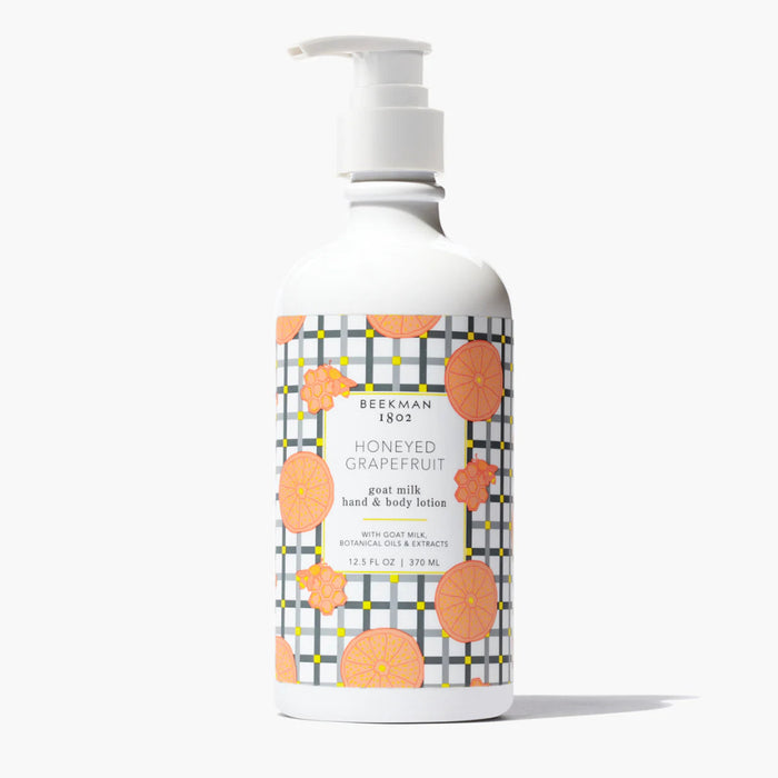 Bottle of Beekman 1802 Honeyed Grapefruit hand and body lotion on a white background