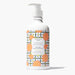 Bottle of Beekman 1802 Honeyed Grapefruit hand and body lotion on a white background