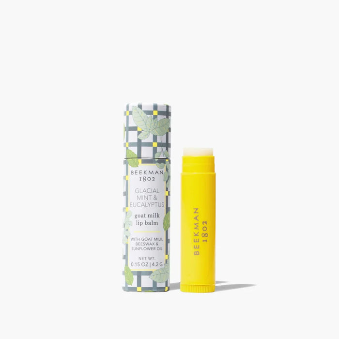 A tube of lip balm featuring a yellow and white patterned design.