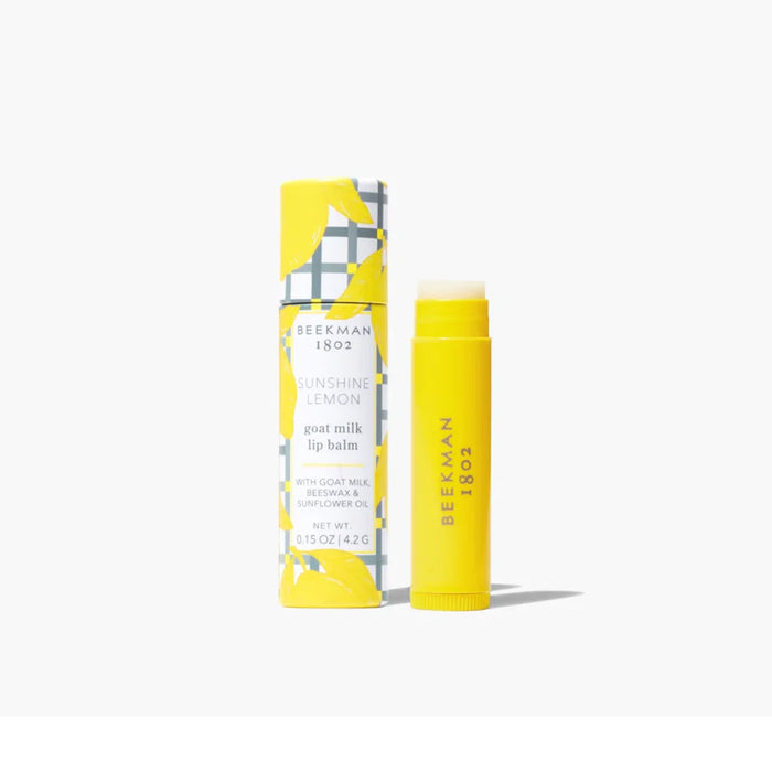 A tube of lip balm featuring a yellow and white patterned design.
