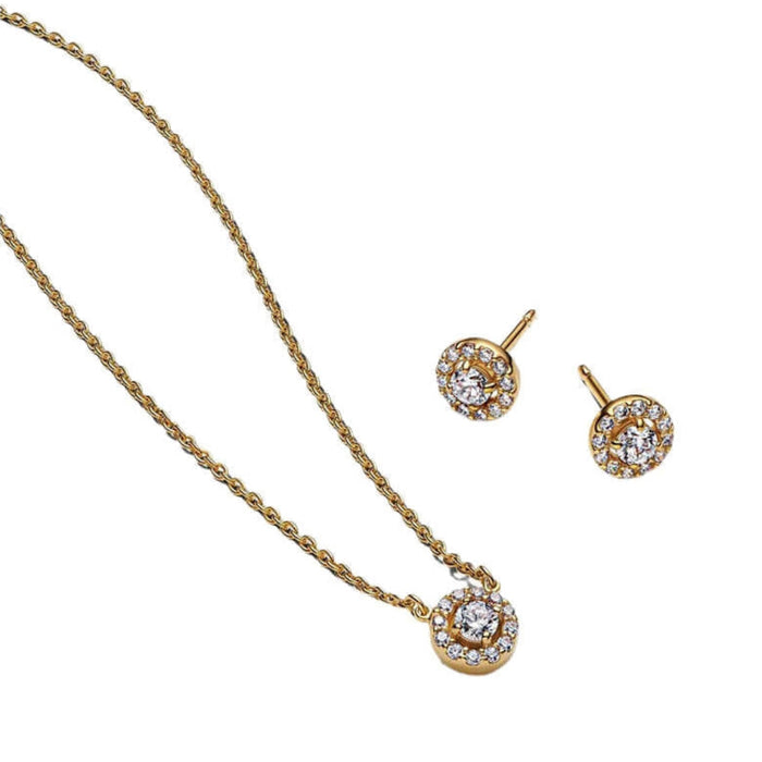 Gold necklace and earrings set on a white background