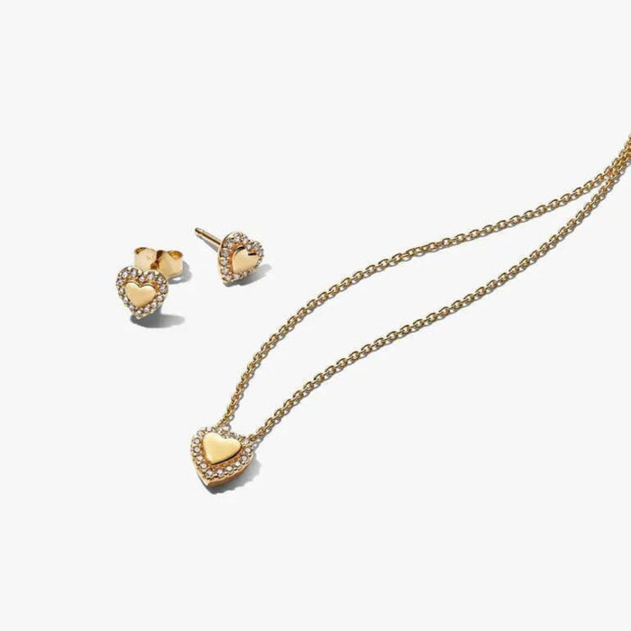 Gold heart-shaped necklace and earrings on a white background