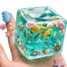 Think Sweet Squishy Fun Box Deluxe with eight toys: dumpling, strawberry, axolotl, two cubes, glitter ball, butter, and cow.