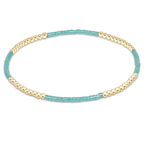 "Hand beaded on high performance elastic for a slight stretch to easily roll on and off your wrist"