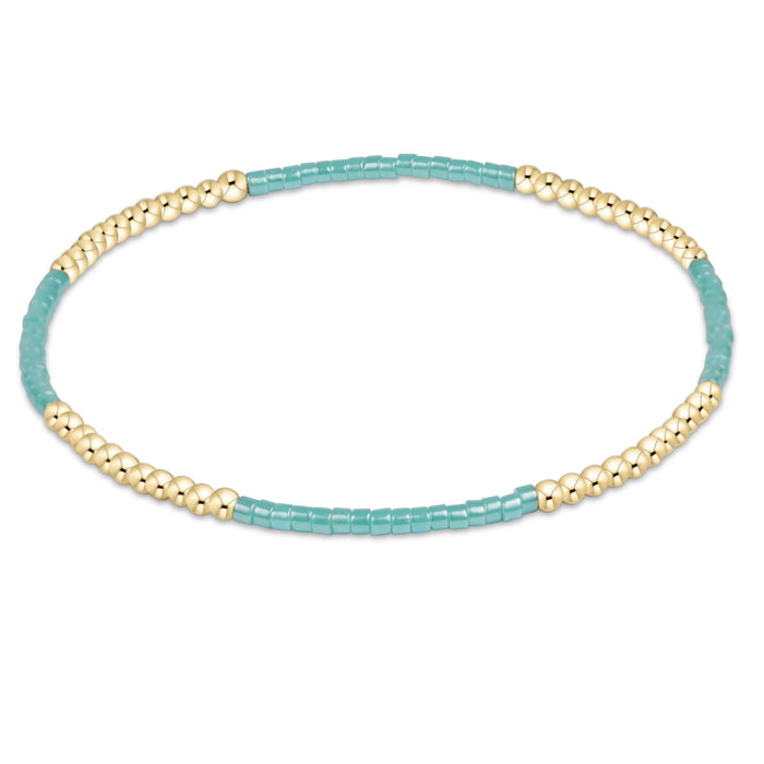 "Hand beaded on high performance elastic for a slight stretch to easily roll on and off your wrist"