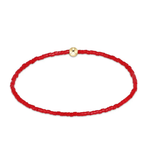 A red beaded bracelet with a small gold-toned circular bead at the top, displayed on a clean white background.