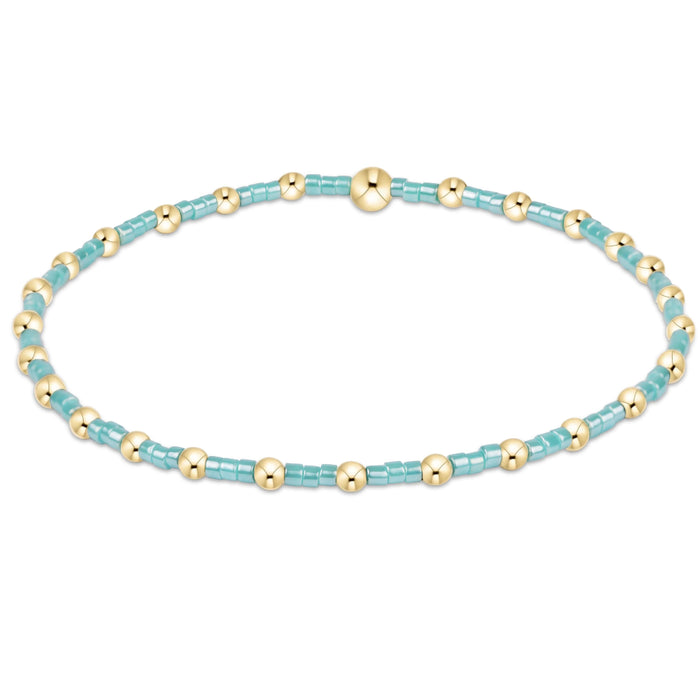 "Hand beaded on high performance elastic for a slight stretch to easily roll on and off your wrist"