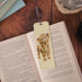 A whimsical bookmark adorned with a cheerful cow illustration, ideal for marking pages in your favorite books.
