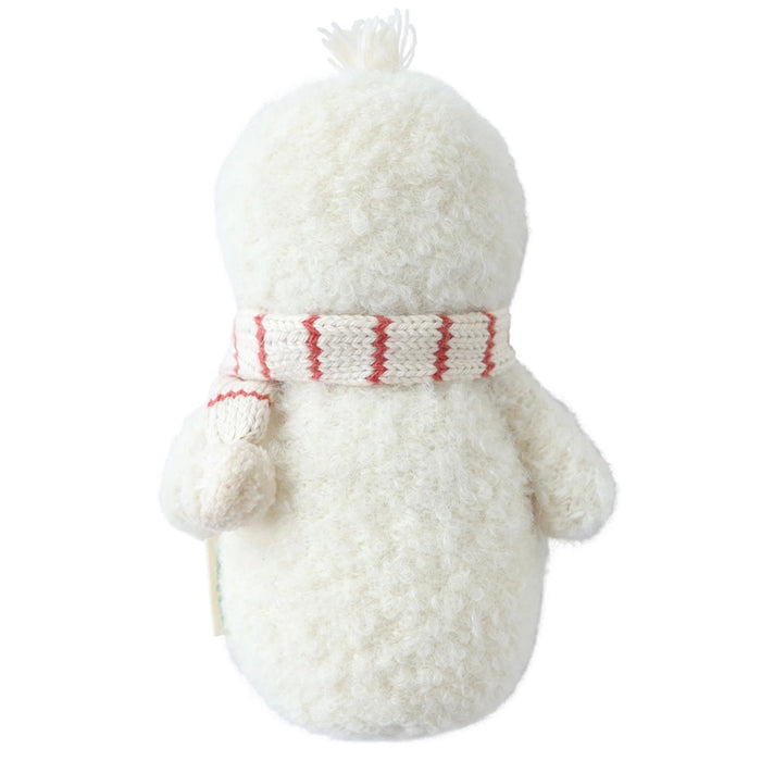 Back view of hand-knit baby snowman doll with fluffy white body and candy cane striped scarf.