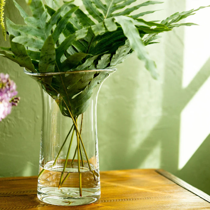 A table set with a vase of fresh flowers and a glass of water, creating a serene atmosphere.