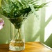 A table set with a vase of fresh flowers and a glass of water, creating a serene atmosphere.