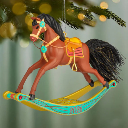 Decorative horse ornament on a tree with '2026' on a colorful base.
