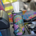 Floral-patterned tissue holder in a car console with colorful interior.