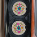 Two decorative car coasters showcasing an array of colorful flowers.