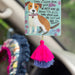 Decorative air freshener with a dog motif and a colorful tassel hanging from it.