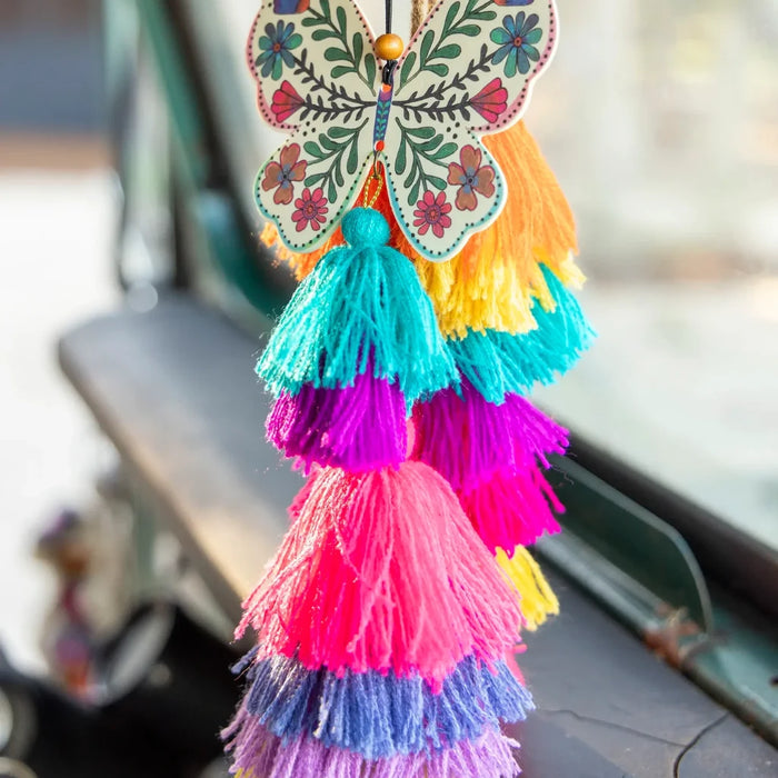 An air freshener in the shape of a butterfly, featuring a tassel attached for added decoration.