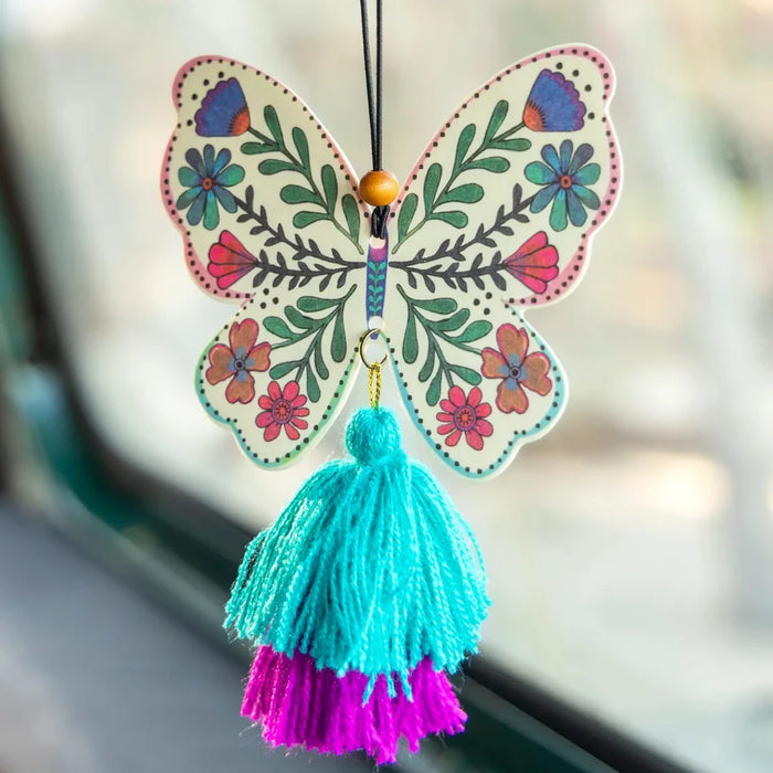 A butterfly air freshener adorned with a colorful tassel, hanging elegantly from its base.