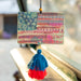  A tassel hangs from a window sill beside an American flag, symbolizing patriotism and home decor.