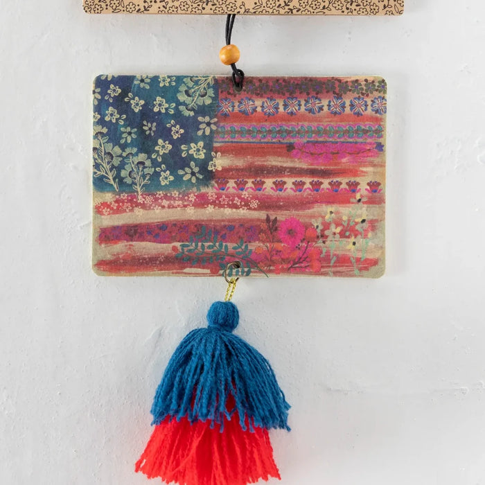 An American flag is displayed alongside a tassel hanging from a window sill, blending decor with patriotism.