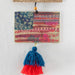 An American flag is displayed alongside a tassel hanging from a window sill, blending decor with patriotism.