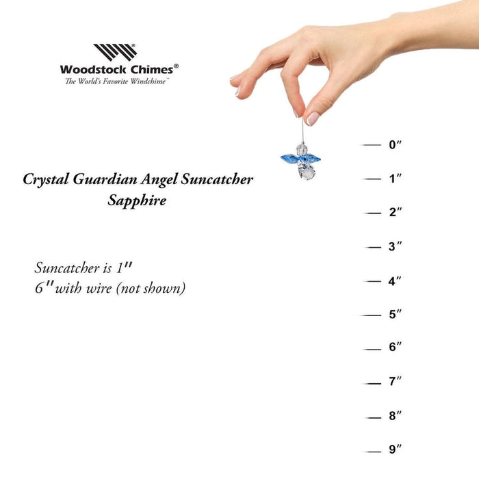 Hand holding a Crystal Guardian Angel Suncatcher with measurement scale on a white background, featuring Woodstock Chimes branding.