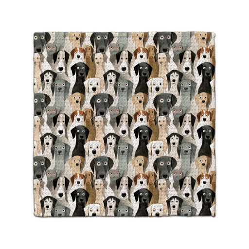 A cozy blanket featuring various dog breeds in a colorful pattern, showcasing their unique shapes and expressions.
