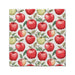 A white napkin adorned with a vibrant red apple pattern.