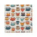 A decorative napkin adorned with a pattern of colorful coffee cups, arranged in a playful design.
