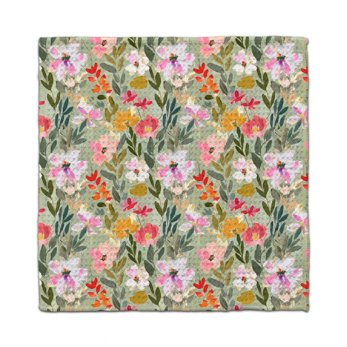 A floral napkin featuring a pattern of green, pink, and yellow flowers on a white background.
