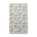 A bright towel displaying a floral pattern, complete with colorful birds and leaves, perfect for adding charm to any space.