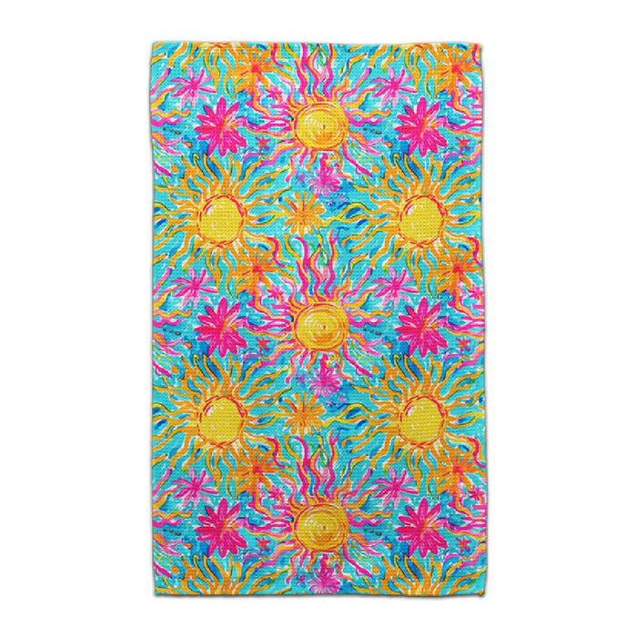 A colorful towel with a sun print on a blue background, adding a bright touch to any beach or pool setting.