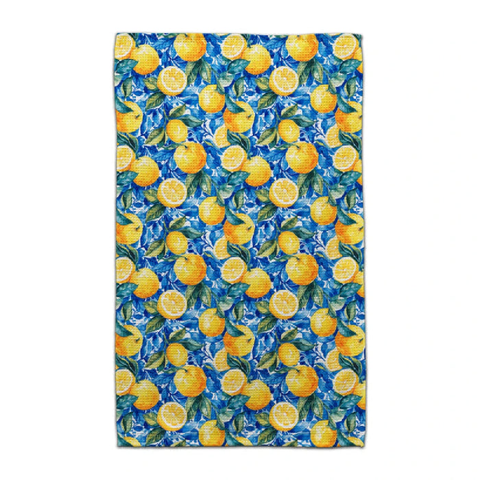 A towel featuring a pattern of lemons and green leaves on a light background.