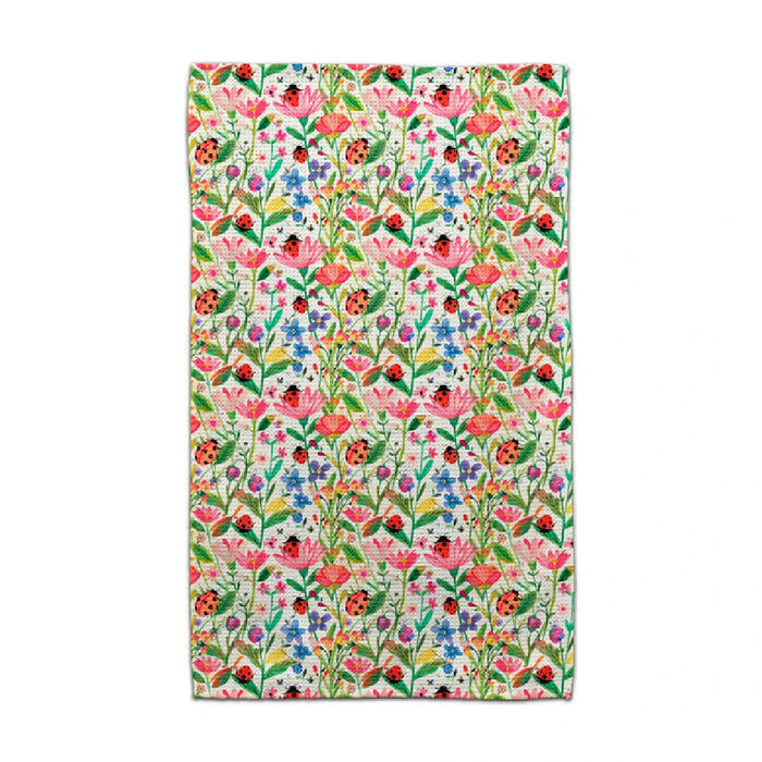 A towel featuring a vibrant pink and green floral pattern, showcasing a lively and decorative design.