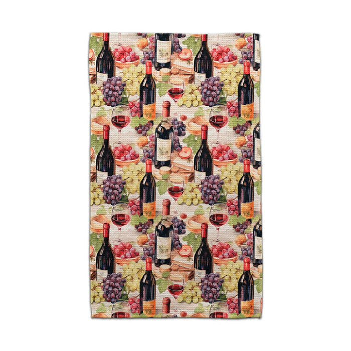 CJ Bella towel with a repeating pattern of wine bottles, red wine glasses, and purple, green, and red grape clusters.