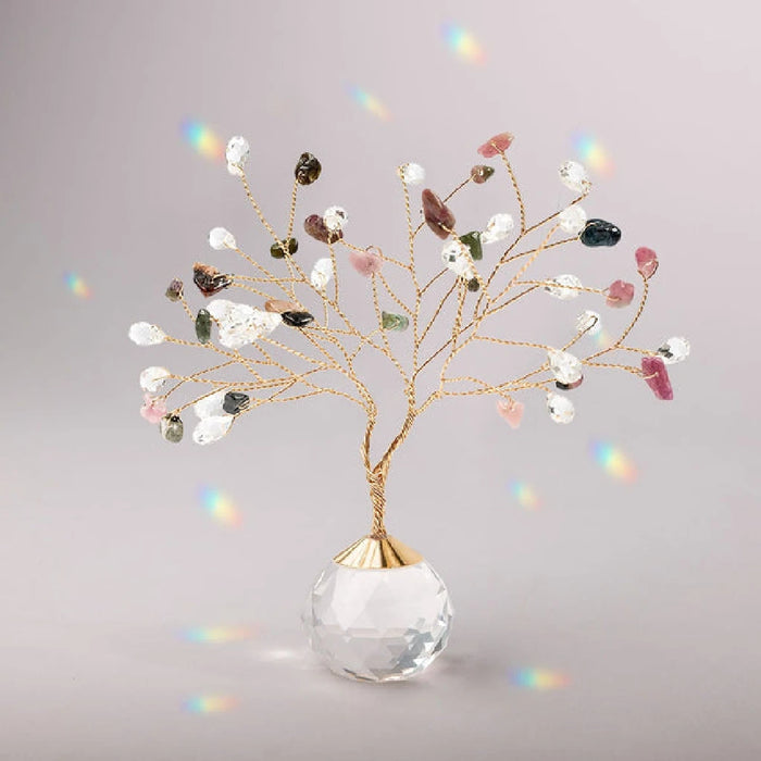Suncatcher Tree of Life with tourmaline crystals hanging in sunlight casting rainbow reflections
