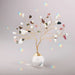 Suncatcher Tree of Life with tourmaline crystals hanging in sunlight casting rainbow reflections