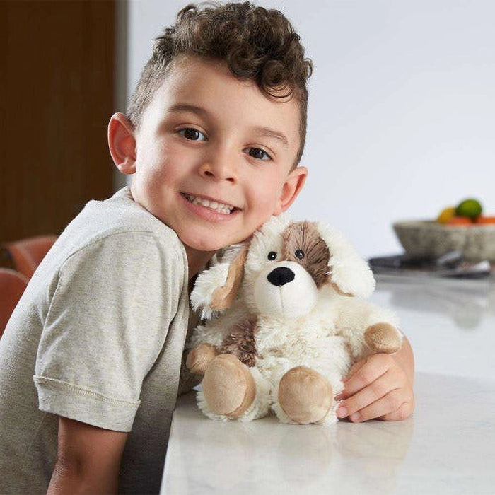 Child holding a plush dog toy in a kitchen setting