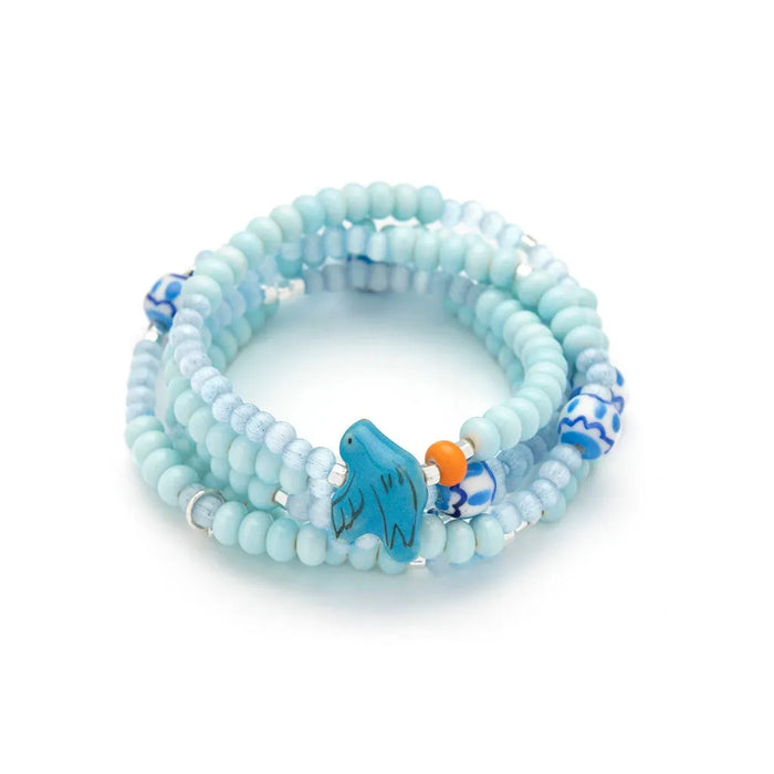 Scout Curated Wears Joy/Bluebird wrap bracelet/necklace with pale blue ceramic beads, patterned beads, and bluebird charm.