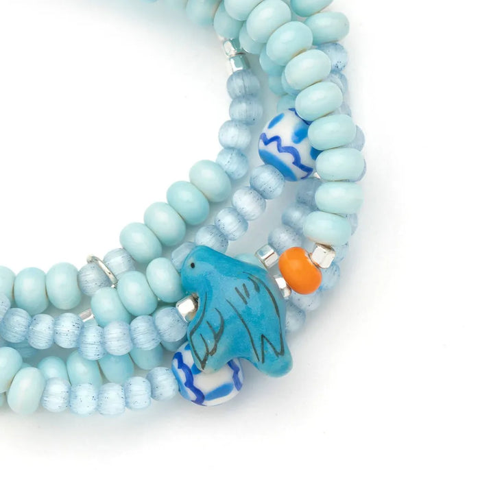 Scout Curated Wears Joy/Bluebird wrap bracelet/necklace with pale blue ceramic beads, patterned beads, and bluebird charm.