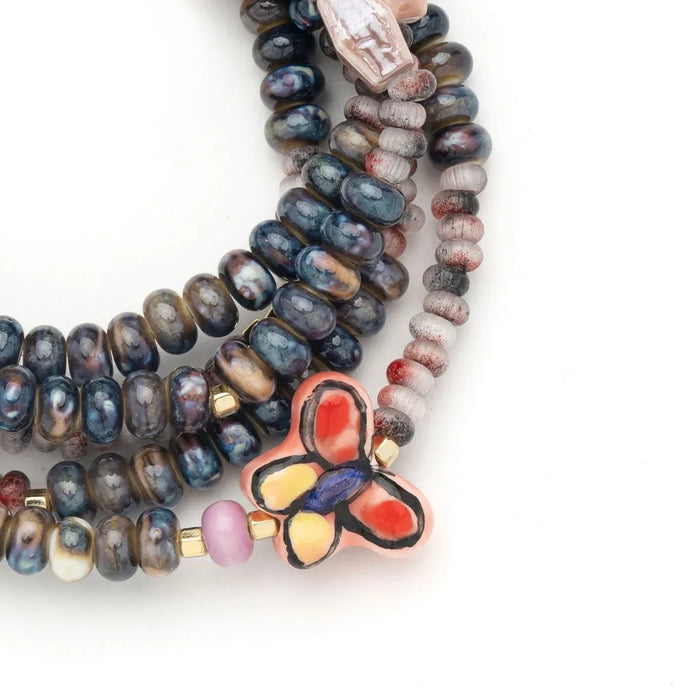 Scout Curated Wears ceramic bead wrap bracelet/necklace with multicolored beads and butterfly charm on Transformation card.
