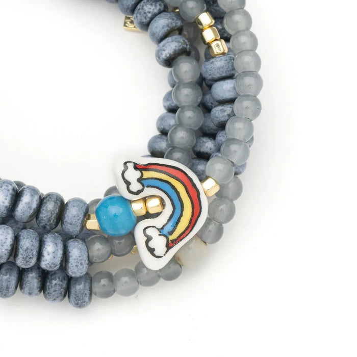 Scout Curated Wears Hope/Rainbow ceramic bead wrap bracelet and necklace with gray beads, gold-tone accents, and a colorful rainbow charm.