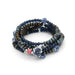 Scout Curated Wears Peace/Dove ceramic bead wrap bracelet/necklace with dark navy, muted green, and bronze-toned round beads, silver-toned spacers, blue-and-white patterned ceramic accents, and a white dove-shaped charm with blue detailing.