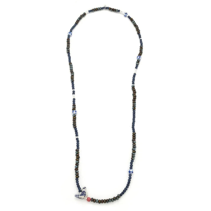 Scout Curated Wears Peace/Dove ceramic bead wrap bracelet/necklace with dark navy, muted green, and bronze-toned round beads, silver-toned spacers, blue-and-white patterned ceramic accents, and a white dove-shaped charm with blue detailing.