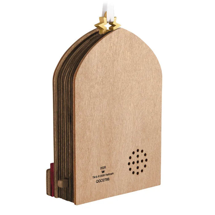 Side profile of layered wood papercraft ornament revealing speaker grille, perforations, and 2026 copyright mark